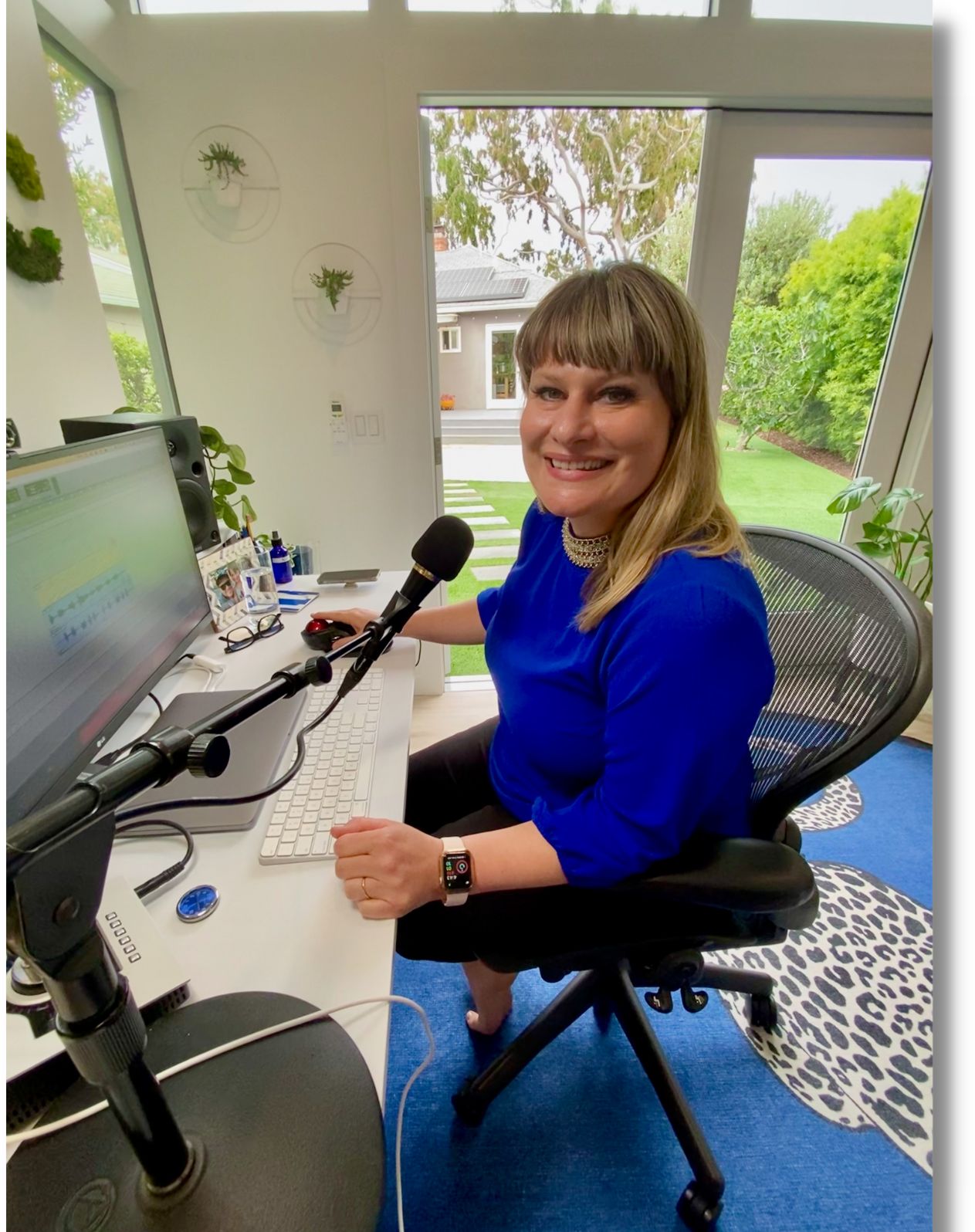 Charissa working at the Studio C desk with microphone and screens
